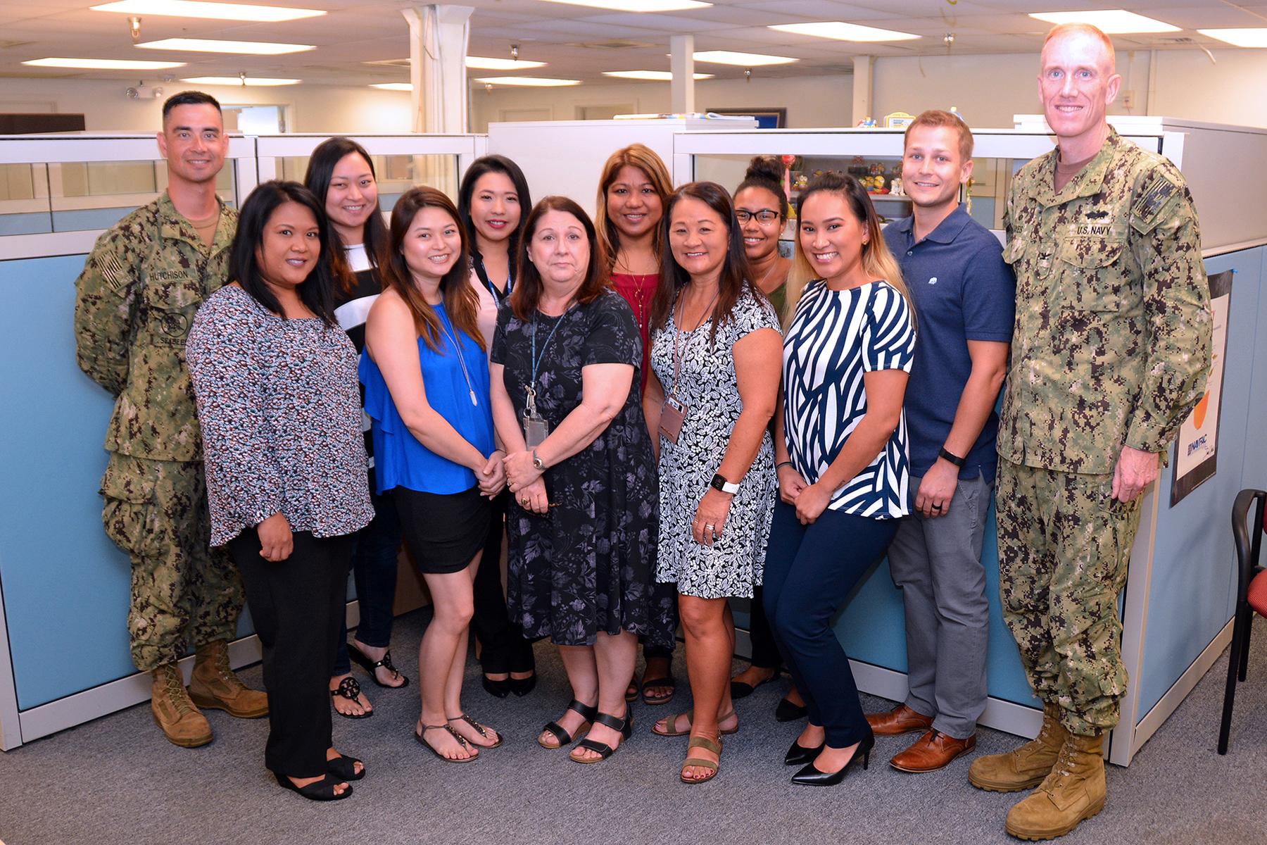 a group of people standing in a room - File:NAVFAC Hawaii Coin Awarded for Career Fair Success (4144